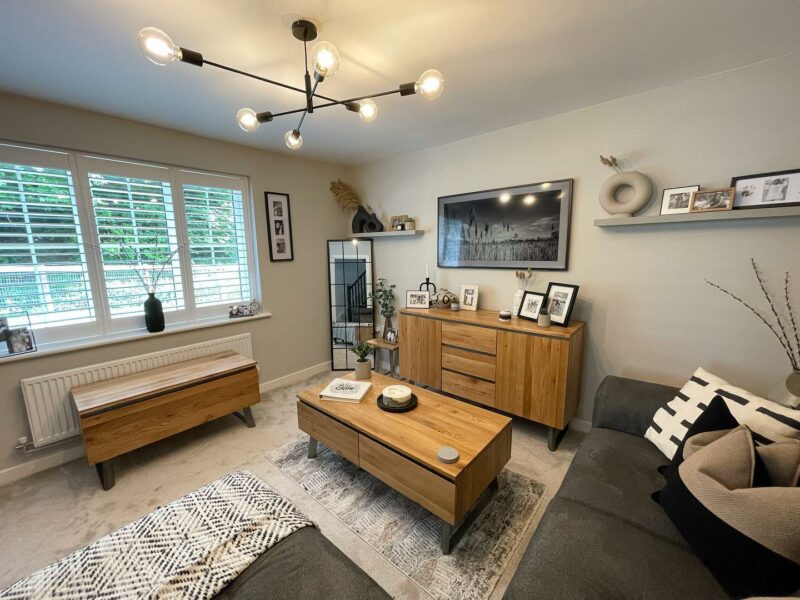 Living room with Boston oak and metal furniture, including coffee table, sideboard, and blanket box in a monochrome scheme.