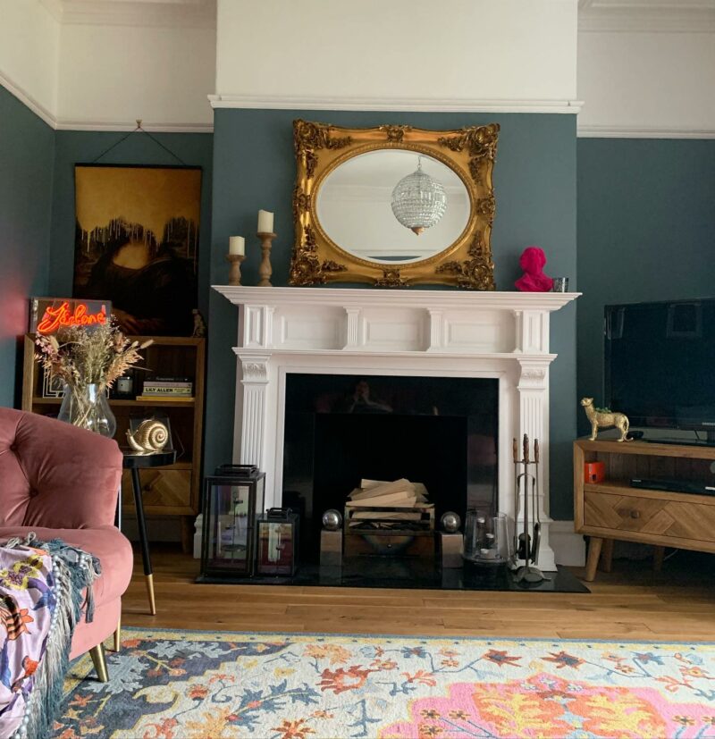 Parquet TV stand in a living room with blue walls and a patterned rug.