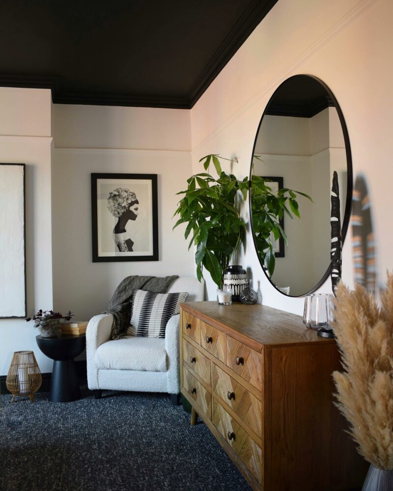 Oak Furnitureland Parquet chest of drawers in a living room with a cream accent chair and houseplants.