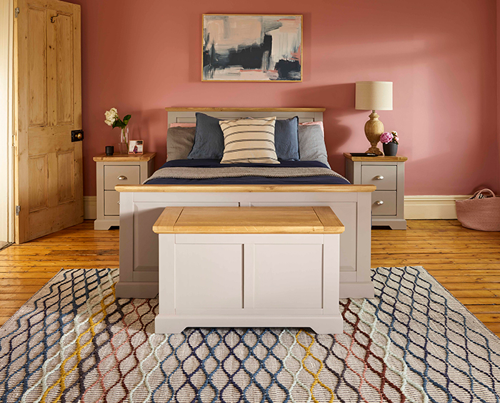 Oak Furnitureland St. Ives painted grey bedroom range with pink walls, colourful rug and statement artwork.