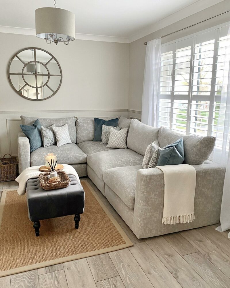 Oak Furnitureland Malvern grey fabric corner sofa with blue and cream scatter cushions.