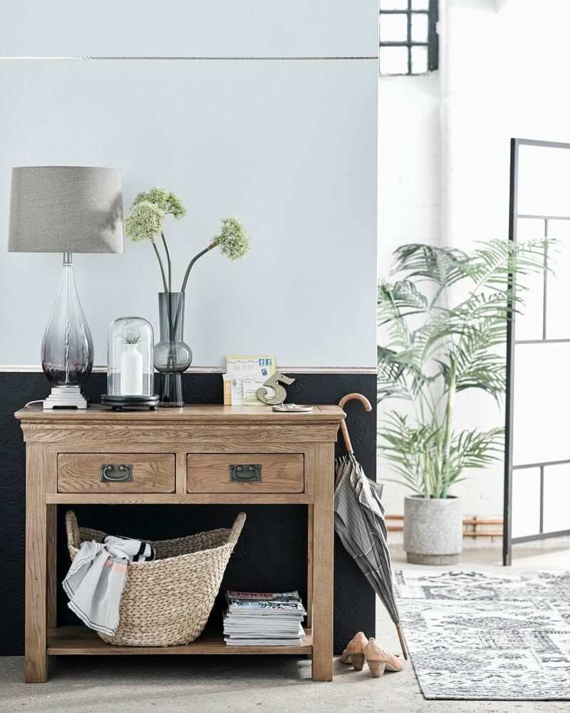 French Farmhouse console table in a light and airy hallway with plants and accessories.