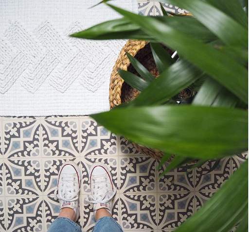 grey mosaic tiled floor with plant and shoes