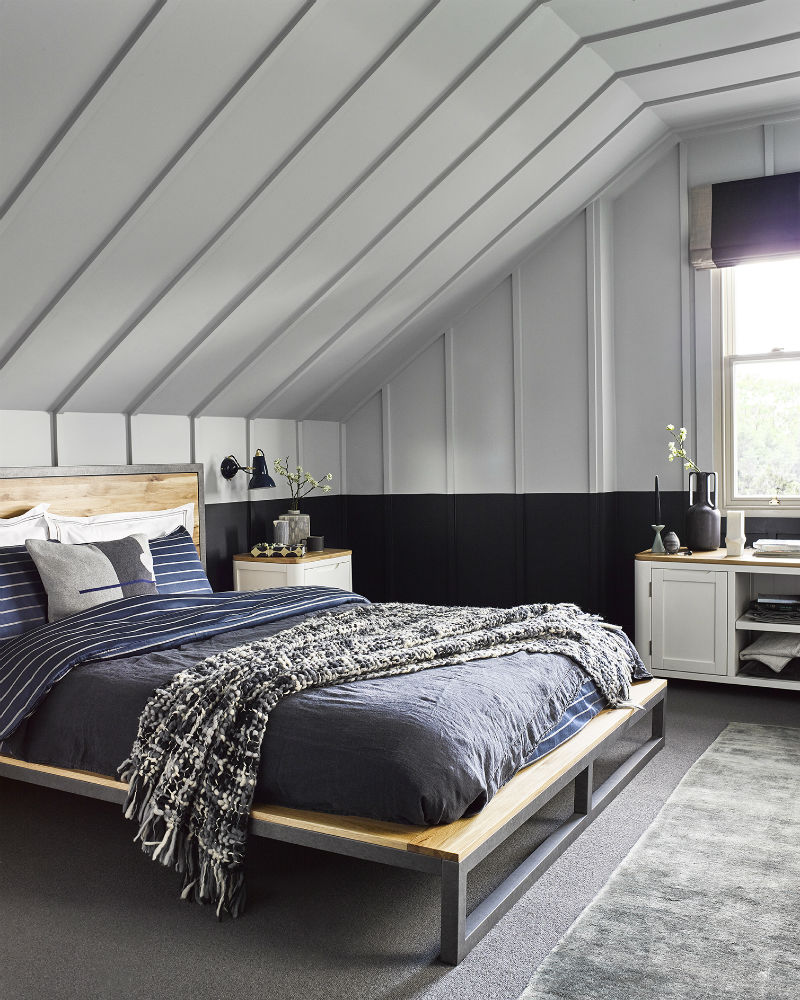 Grey panelled loft conversion bedroom with industrial style bed