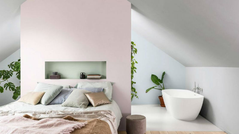 bedroom with pink feature wall and floating bath tub