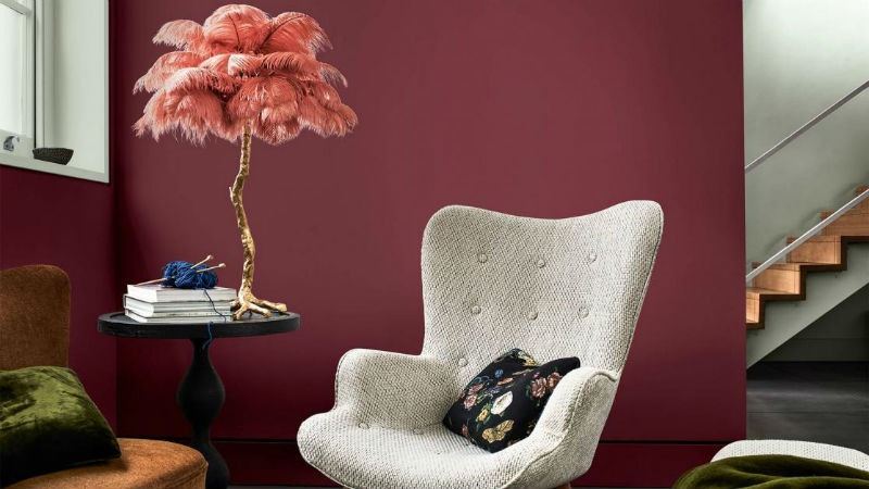 living room with dark plum feature wall and grey accent chair