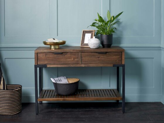 Oak Furnitureland Detroit dark glazed console table against a blue backdrop.