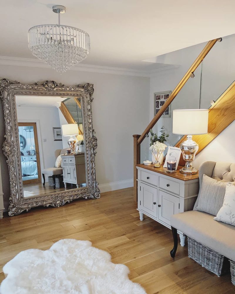 grey living room with large ornate mirror and grey sideboard