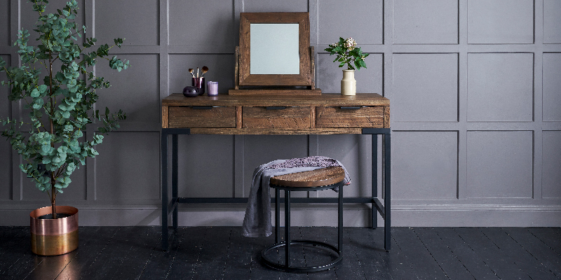 dark wood dressing table against blue panelled wall