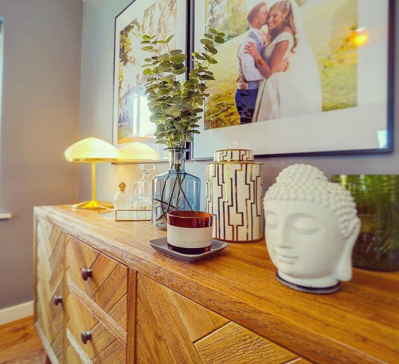 Close up of the Oak Furnitureland Parquet sideboard topped with global-inspired decorative objectives.