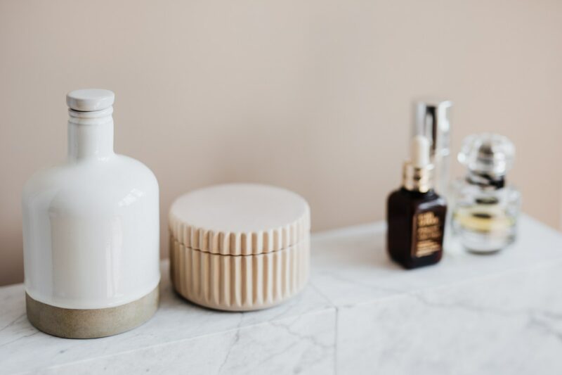 Bathroom accessories on a marble shelf.