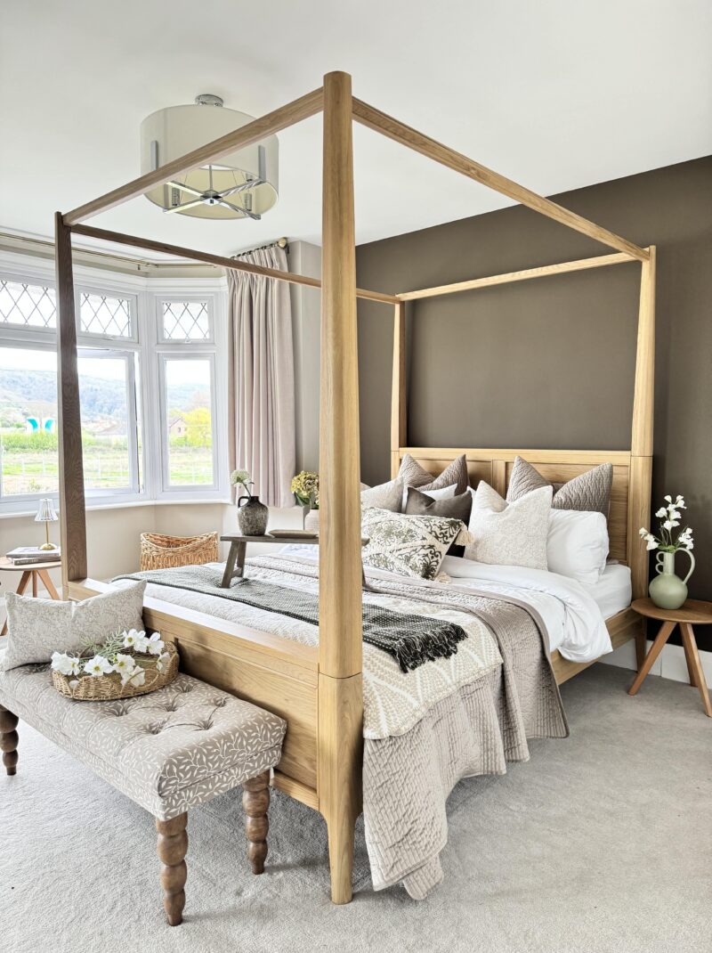 A bed, side table and bench- bedroom furniture-wooden four-poster bed-neutral design-layered bedding