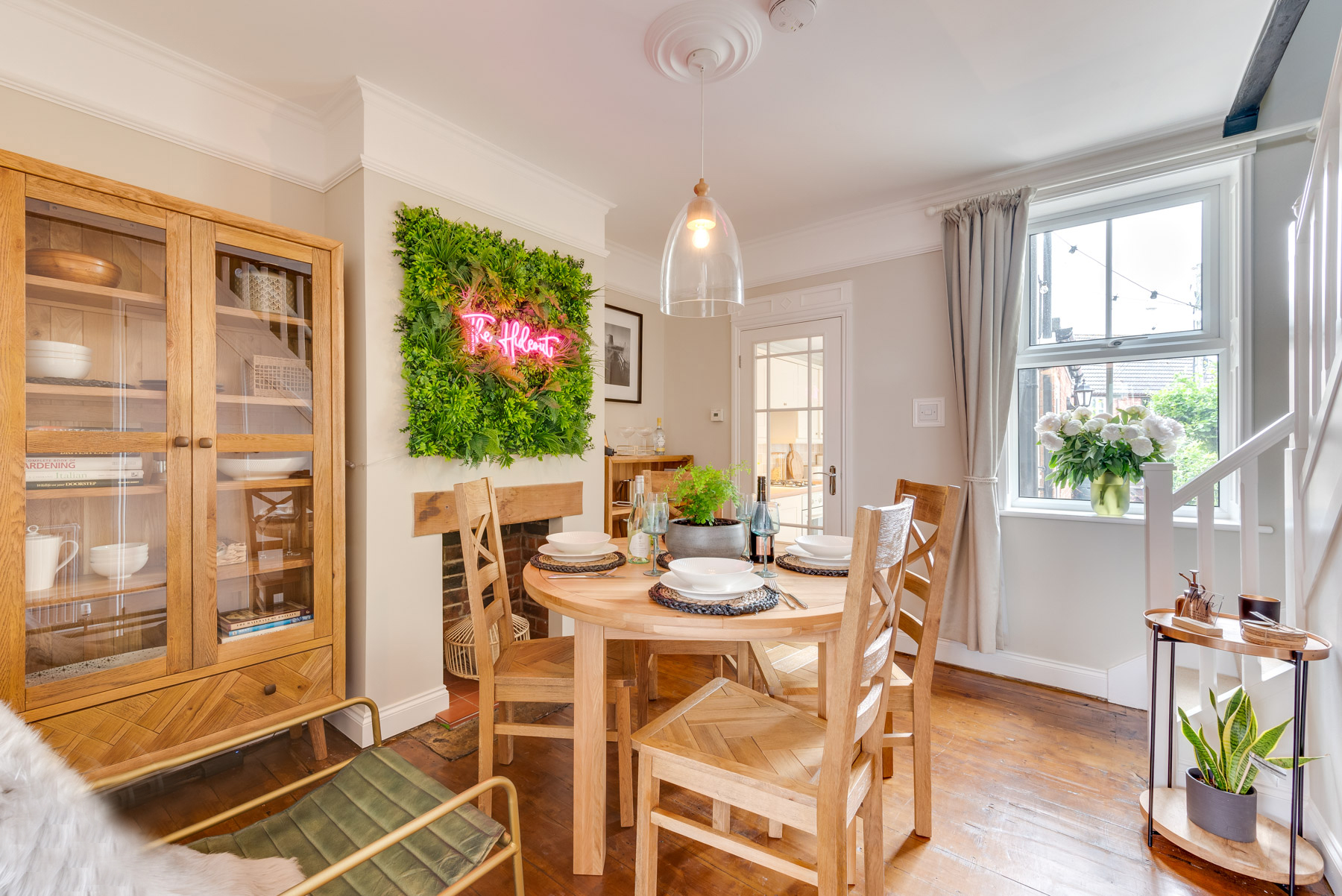 Oak Furnitureland Knightsbridge dining table and Parquet display cabinet in bright room with neon sign