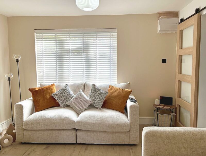 Malvern beige sofa topped with burnt orange and patterned scatter cushions.
