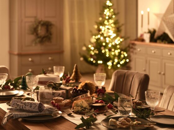 Dorset natural oak dining table set for Christmas with a twinkling tree in the background.