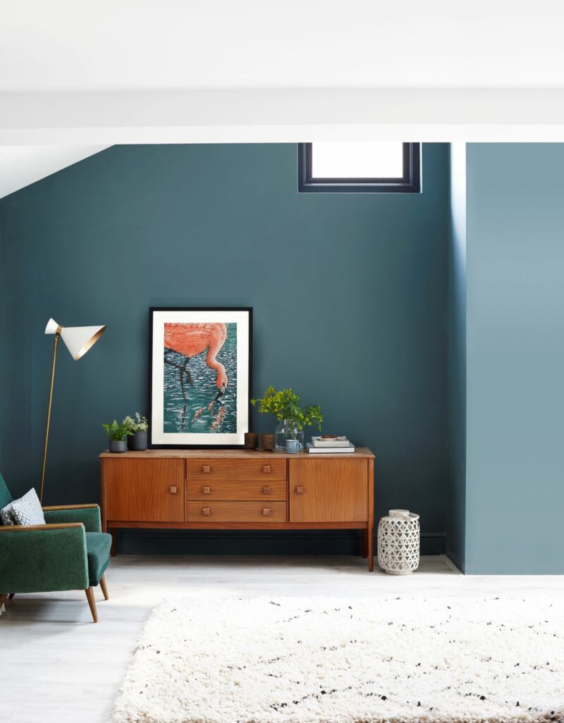 Living room with blue walls and retro-inspired furniture.