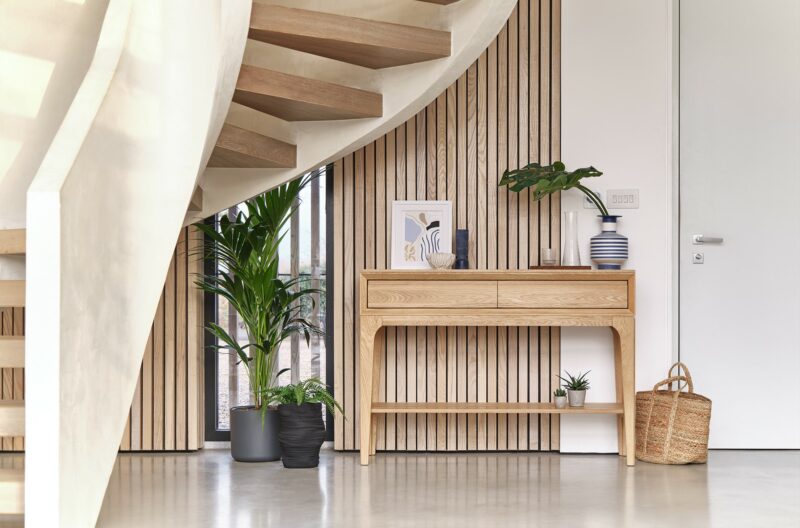 Oak Furnitureland Aston range console table in a dramatic modern hallway with a sweeping staircase.