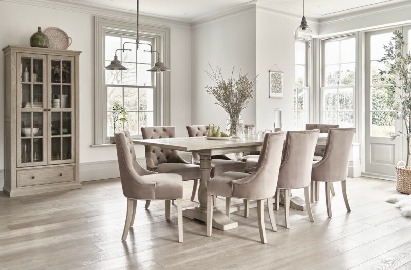 Oak Furnitureland Burleigh extendable dining table in a light-filled room with a matching glazed cabinet.