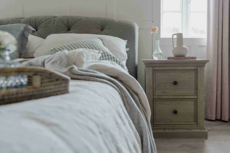 Burleigh weathered oak bedside table in a white and pink bedroom.
