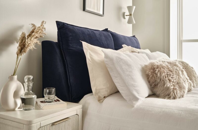 A bed and bedside table-bedroom furniture-upholstered blue king-size bed-wooden bedside table with drawers-layered bedding