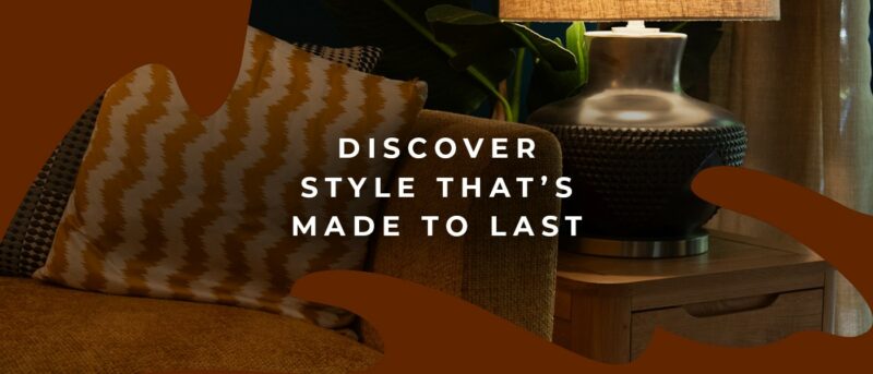 Close up of a yellow sofa with a patterned accent cushion and a lamp on a side table.