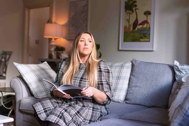 A portrait of Millie McClure, Boardwalk Property-living room-grey sofa-framed artwork-check cushions