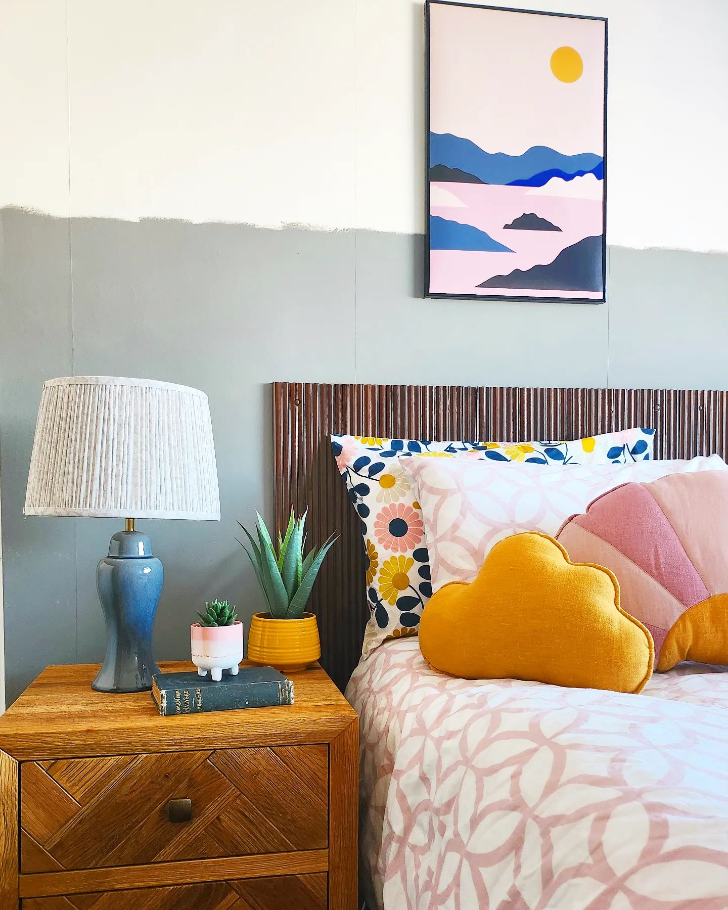 A bed and bedside table-bedroom furniture-wooden side table with drawers-patterned bedding-wall art