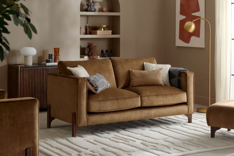 A sofa, sideboard, light and footstool-living room furniture-tan velvet sofa-brass floor lamp-fluted acacia sideboard-arch alcove shelving