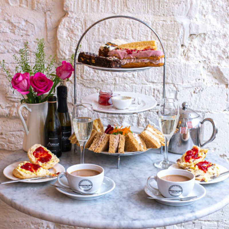 A table and cake stand-dining room furniture-marble table-afternoon tea-champagne-scones-sandwiches-cakes-tea