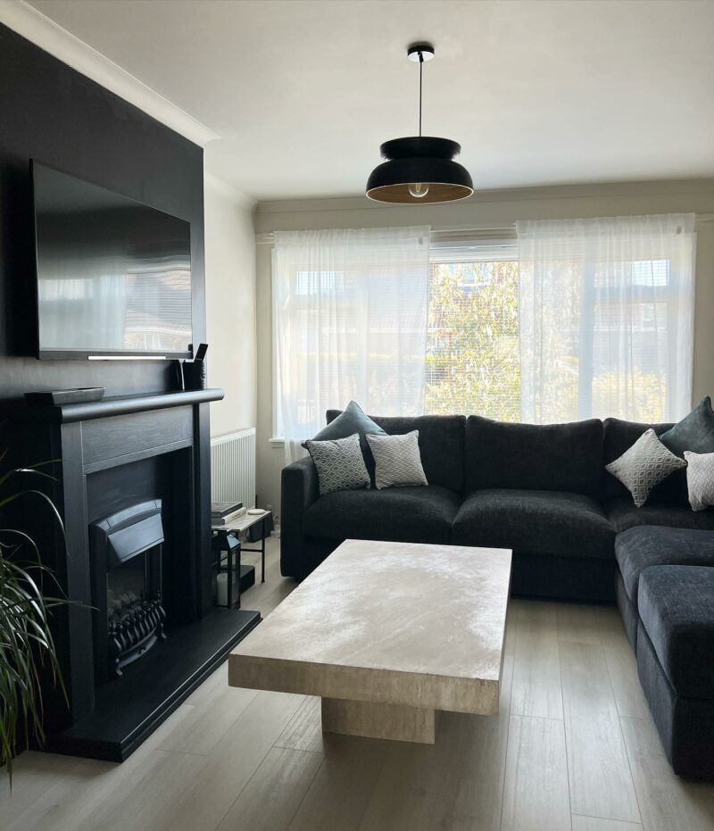 A corner sofa and coffee table-living room furniture-charcoal corner sofa-scatter cushions-fireplace-statement ceiling light