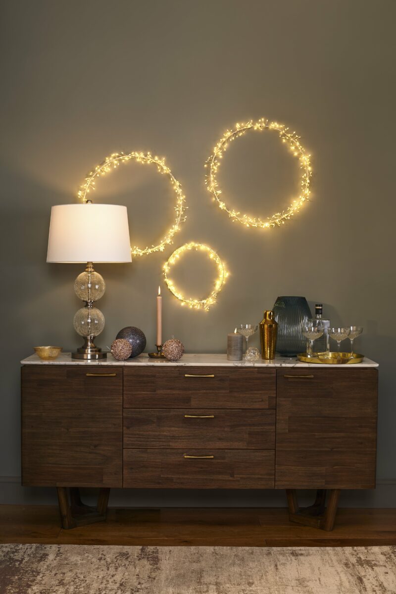 A sideboard-dining room furniture-dark wood and white marble sideboard-neutral rug-glass lamp-cocktail making station-christmas baubles-lighting wreaths