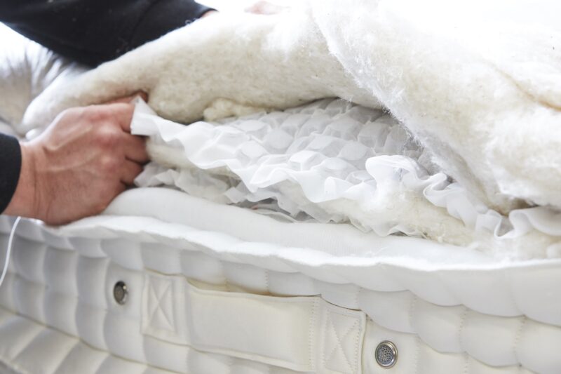 A mattress-bedroom furniture-mattress close up-mattress materials-hand gripping the inside mattress