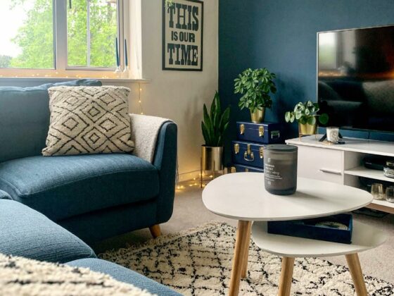A corner sofa-living room furniture-blue L shaped sofa-textured rug-nest of tables-blue feature wall-TV unit